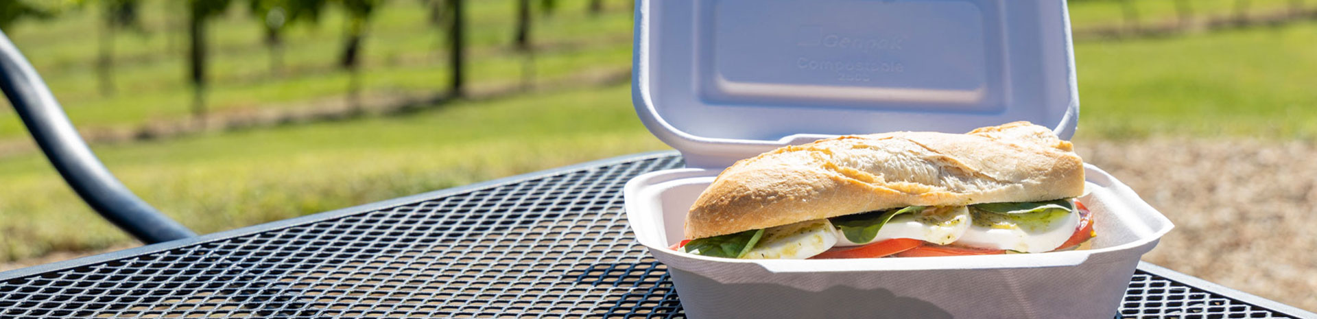 deli sandwich in hinged container on table